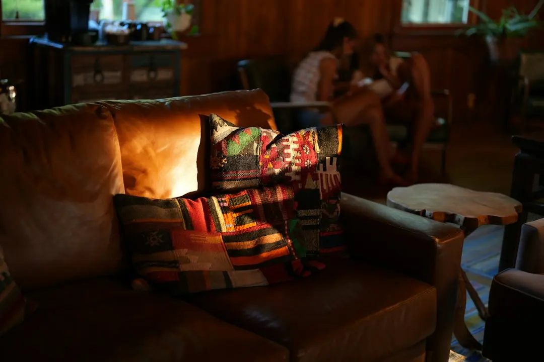 A leather sofa with patterned cushions in a warmly lit living room, an evening spot for browsing the Nartiel8k TV guide